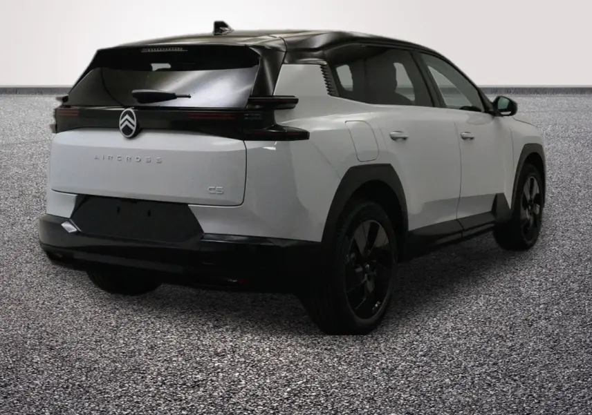 Vue 3/4 arrière droite d'une Citroën C5 Aircross blanche avec toit noir et hayon motorisé, sur sol gris.
