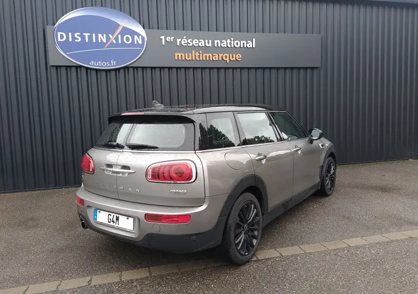 MINI Clubman F54 Silver Metal en 3/4 arrière droit, toit noir et feux arrière rouges sous la pluie.