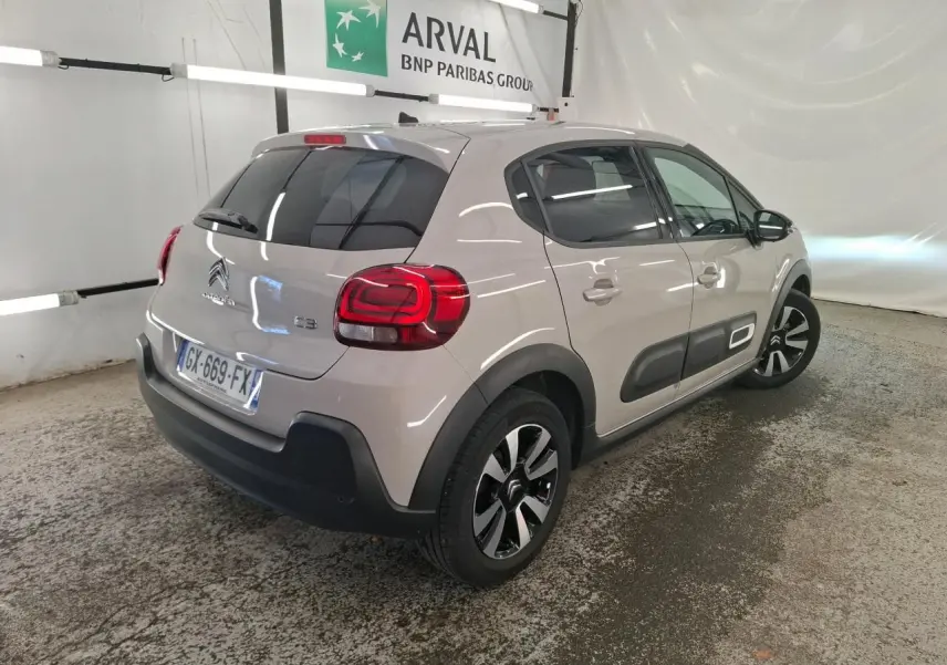 Vue 3/4 arrière droit d'une Citroën C3 beige clair avec protections latérales noires et jantes alliage diamantées.