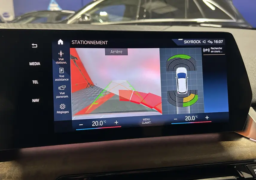 Écran intérieur du BMW Série 2 Active Tourer blanc montrant la caméra de recul et l’aide au stationnement.