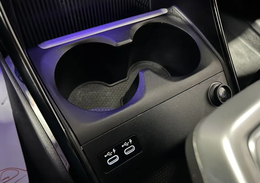 Gros plan sur la console centrale noire du BMW Série 2 Active Tourer avec porte-gobelets et deux ports USB-C.