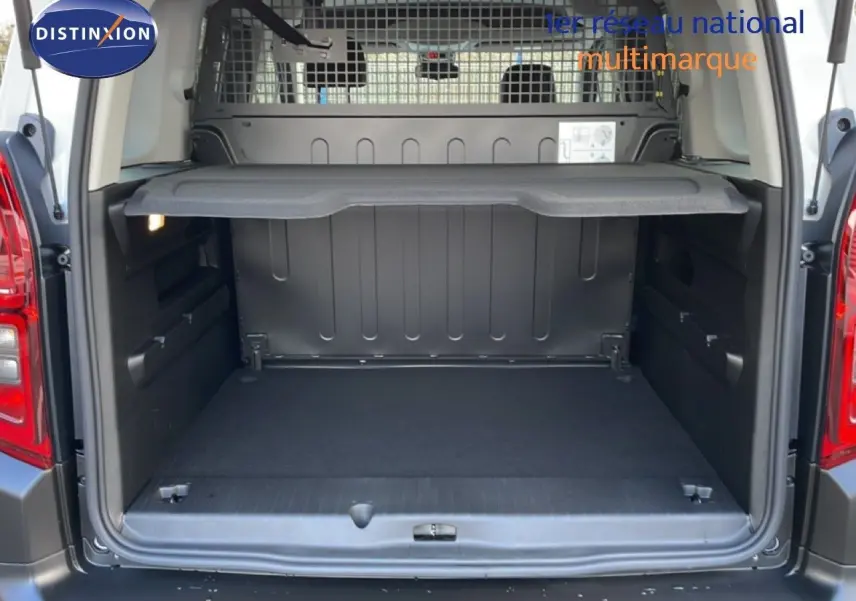 Coffre ouvert d’un Citroën Berlingo blanc glacier 2025, vue arrière montrant l’espace de chargement et la grille de séparation.