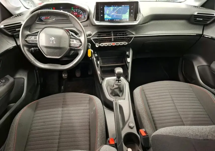 Vue intérieure avant de la Peugeot 208 2020, tableau de bord avec volant compact cuir et écran tactile central.