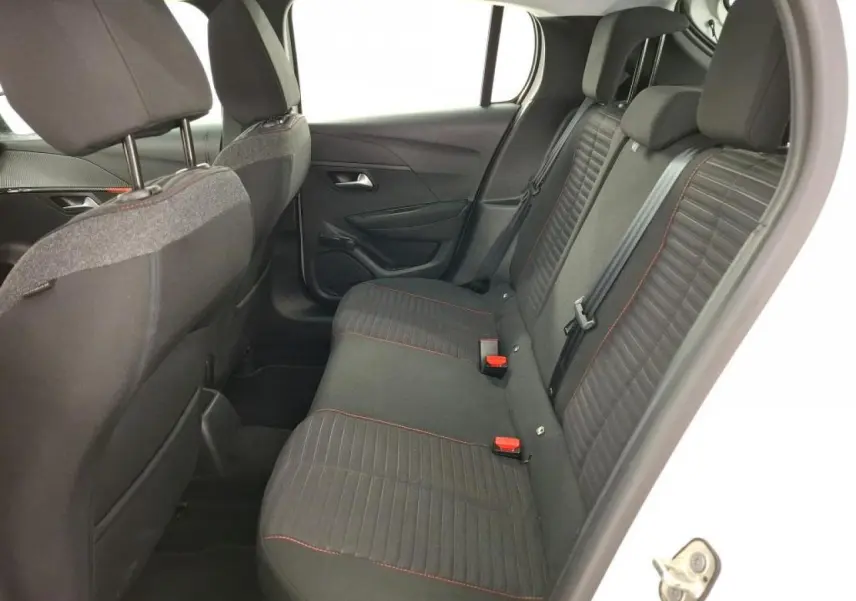 Vue intérieure côté droit sur la banquette arrière noire avec surpiqûres orange de la Peugeot 208 blanche de 2020.
