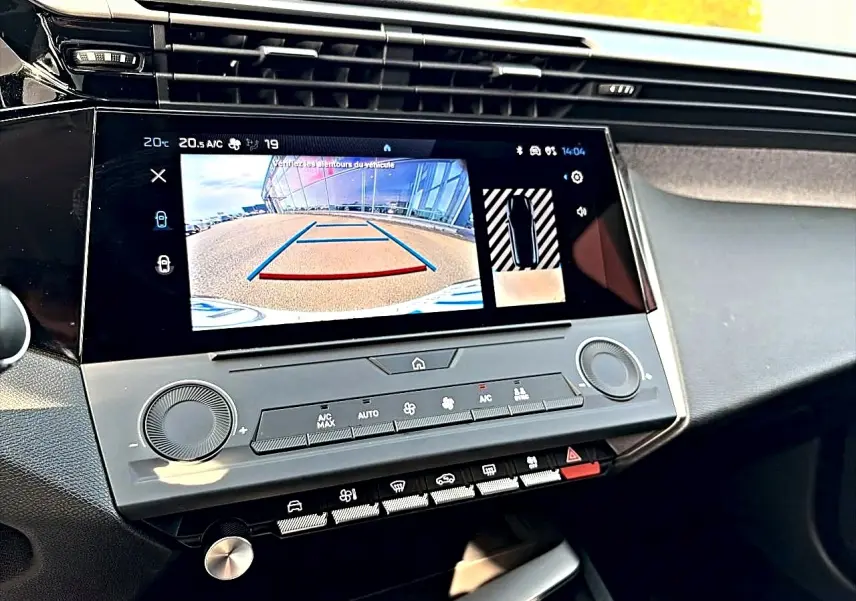Écran tactile central affichant la caméra de recul dans l’habitacle d’une Peugeot 308 noire, vue de face.