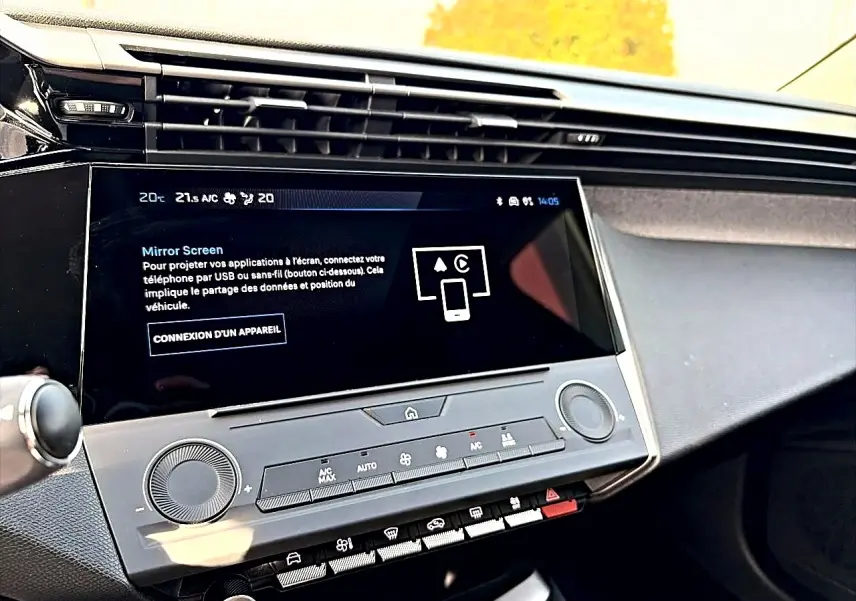 Vue rapprochée de la console centrale noire de la Peugeot 308 2025 avec écran tactile et commandes climatisation.