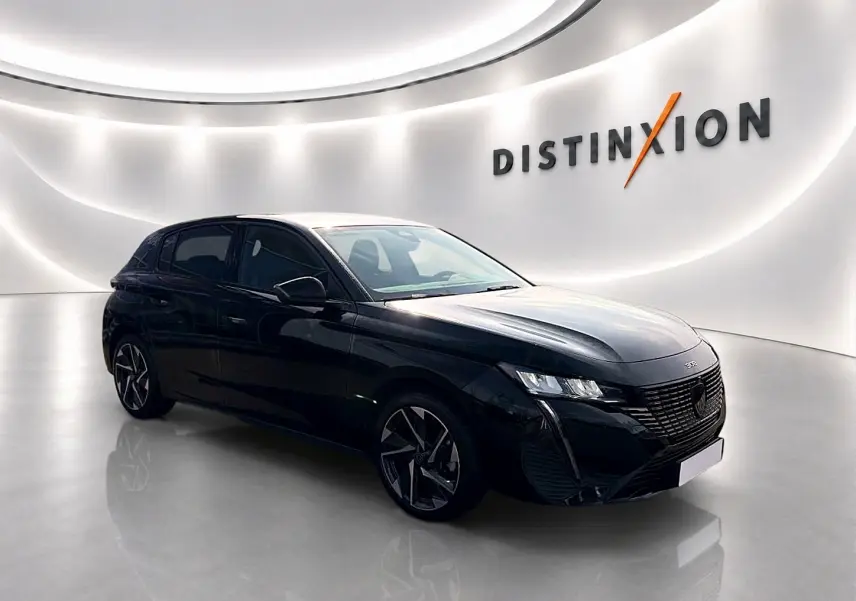 Peugeot 308 noire vue en 3/4 avant droit dans un showroom lumineux avec jantes alu distinctives.