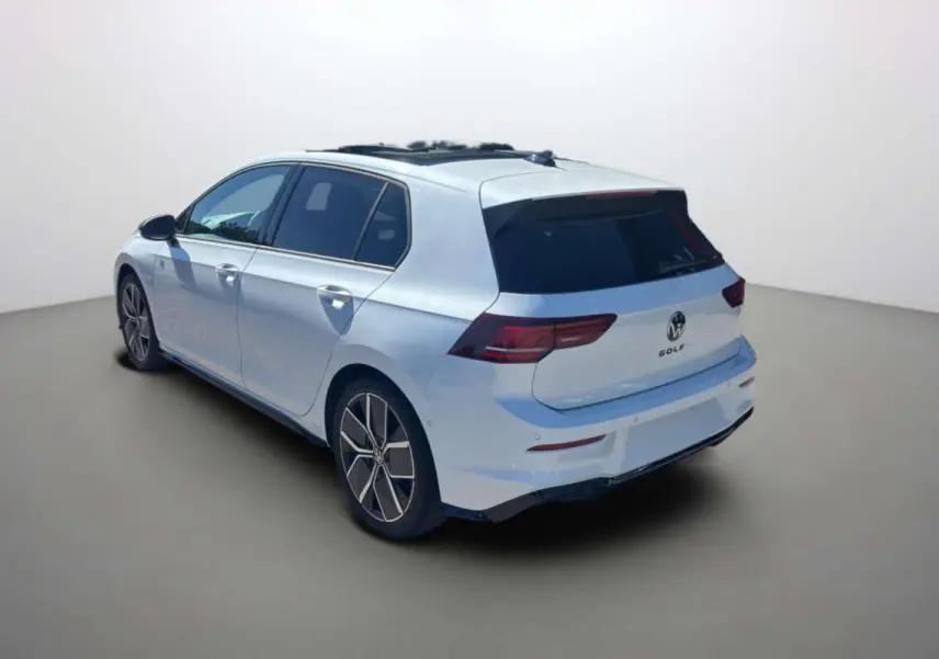 Vue 3/4 arrière droite d'une Volkswagen Golf blanche oryx avec vitres surteintées et jantes alu 18 pouces.