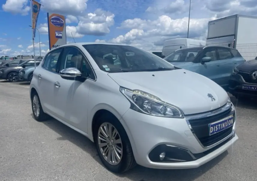 Peugeot 208 blanc perle vue 3/4 avant droit avec jantes alliage et rétroviseurs chromés, stationnée en extérieur.
