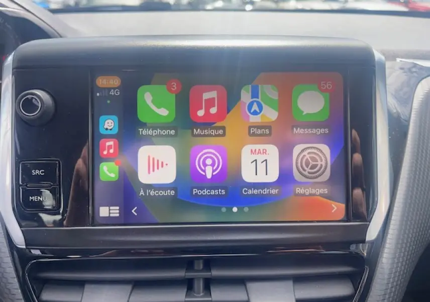 Écran tactile central de la Peugeot 208 blanc perle, affichant l'interface Apple CarPlay en gros plan.