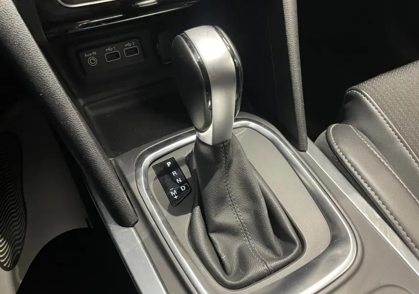 Gros plan sur la console centrale de la Renault Mégane 2023, levier de vitesse automatique et prises USB visibles.