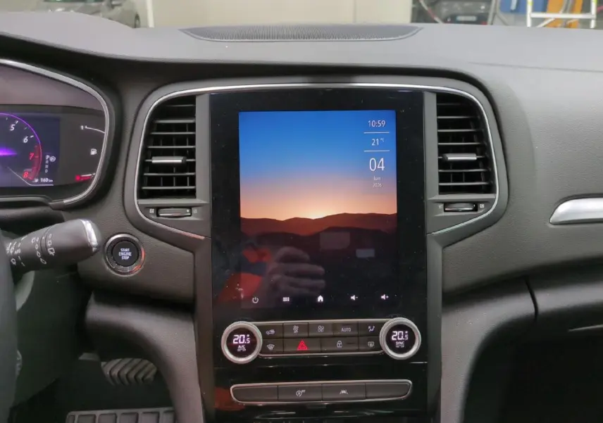 Vue rapprochée de la console centrale de la Renault Mégane 2023 avec écran tactile vertical et commandes climatisation.