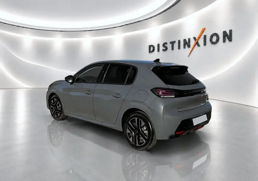 Peugeot 208 gris selenium vue 3/4 arrière droit en intérieur avec jantes alliage noires et vitres teintées.