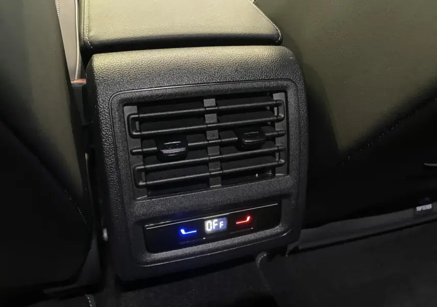 Gros plan sur la sortie d’air arrière noire avec commande de chauffage et ventilation dans une Volkswagen Golf VIII R-Line Black.
