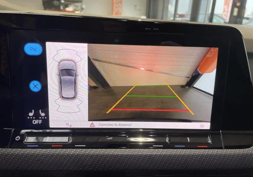 Écran de caméra de recul et capteurs de stationnement de la Volkswagen Golf 8 R-Line noire, vue intérieure du tableau de bord.