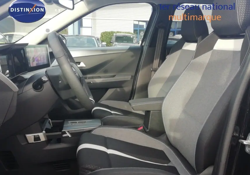 Vue intérieure côté conducteur de l'Opel Frontera 2025, sièges tissu gris noir avec accoudoir central.