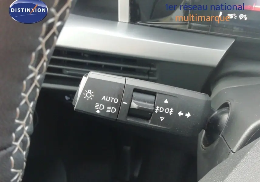 Gros plan sur la commande des phares et clignotants à gauche du volant dans l’habitacle gris noir de l’Opel Frontera 2025 noir Karbon.