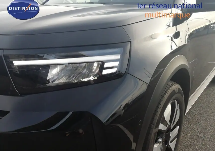 Gros plan sur l'avant droit de l'Opel Frontera 2025 noir Karbon, mettant en valeur son phare LED et sa jante bi-ton.