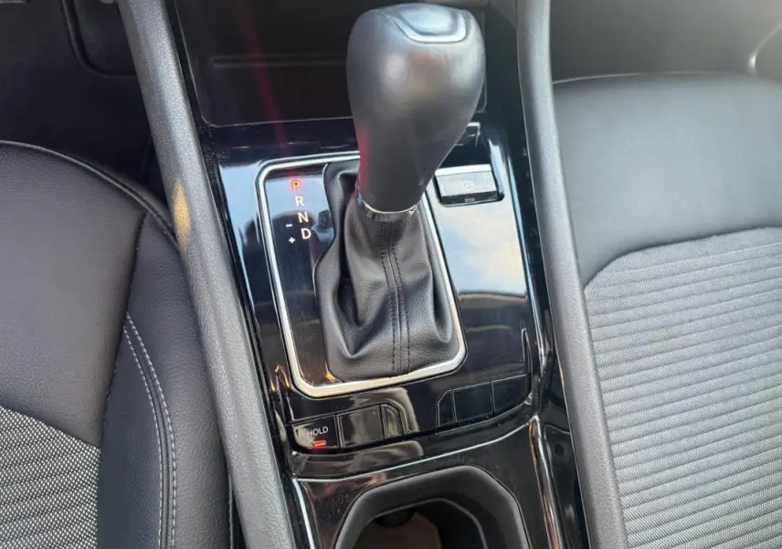 Gros plan sur la console centrale noire avec levier de vitesse automatique et accoudoir en cuir gris du Jeep Compass 2024.