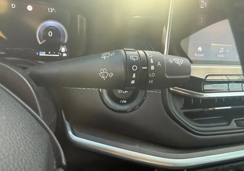 Gros plan sur la commande des essuie-glaces du tableau de bord du Jeep Compass 2024, intérieur noir avec écran tactile.