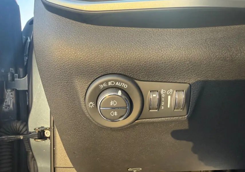 Gros plan sur le panneau de commande des phares et réglages d’éclairage du Jeep Compass 2024, intérieur noir texturé.