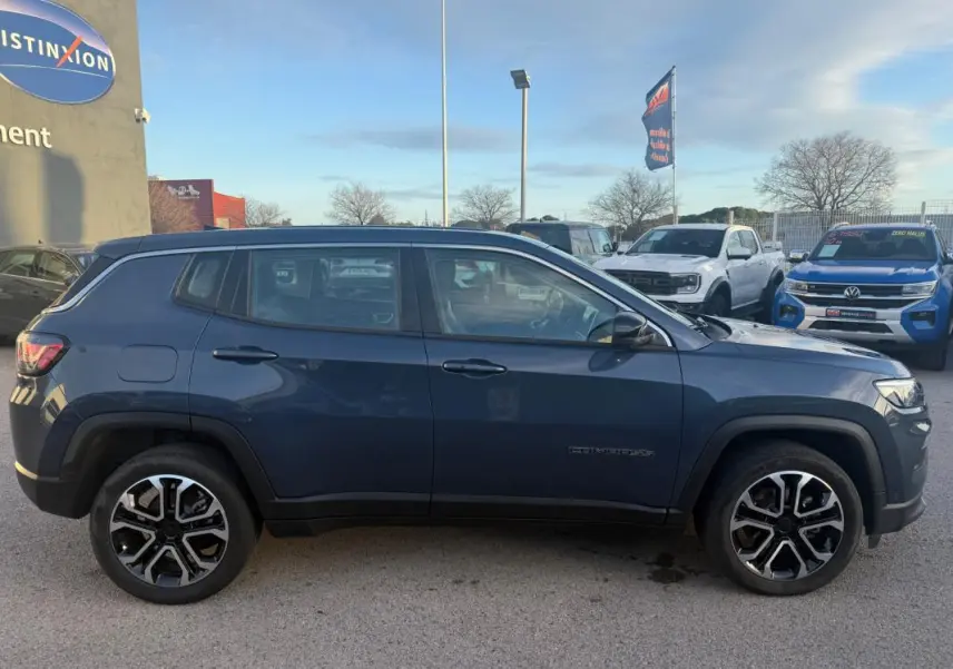 Vue latérale droite d'un Jeep Compass bleu 2024 avec jantes alliage 18 pouces et lignes robustes.