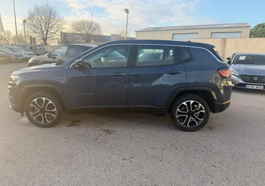 Jeep Compass bleu vue de profil côté gauche, avec jantes alliage 18 pouces et rétroviseurs électriques.