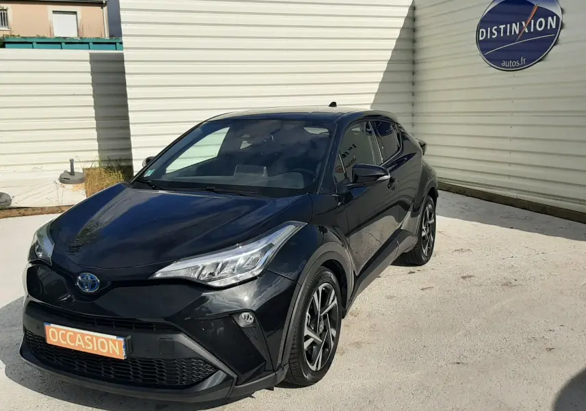 Toyota C-HR 1.8 Hybrid noir vu en 3/4 avant droit, avec jantes alliage et phares LED distinctifs.