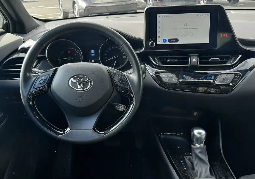 Vue intérieure avant du Toyota C-HR 1.8 Hybrid 122 Design 2023 noir, tableau de bord et volant multifonctions visibles.