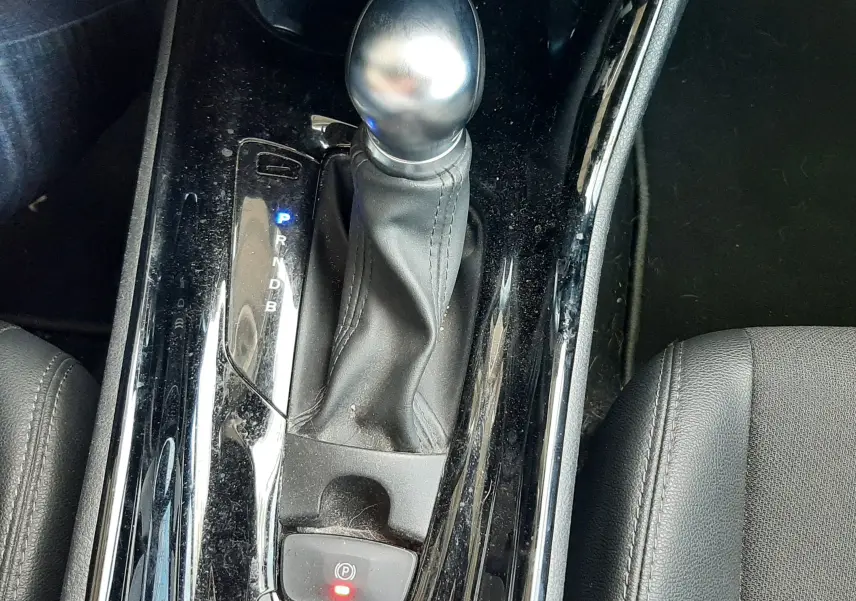 Vue rapprochée de la console centrale noire du Toyota C-HR 1.8 Hybrid 2023, mettant en valeur le levier de vitesse automatique.