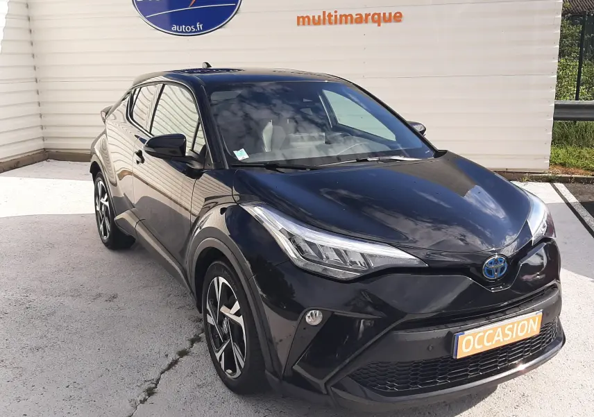 Vue 3/4 avant d'un Toyota C-HR 1.8 Hybrid noir 2023, avec jantes bi-ton et feux LED distinctifs.