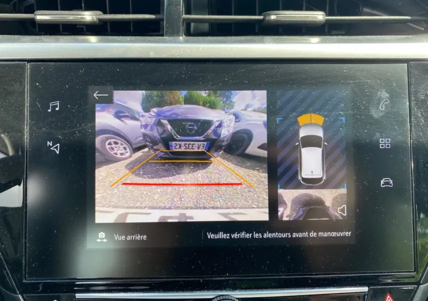 Écran tactile intérieur montrant la caméra de recul avec vue arrière et aide au stationnement active.