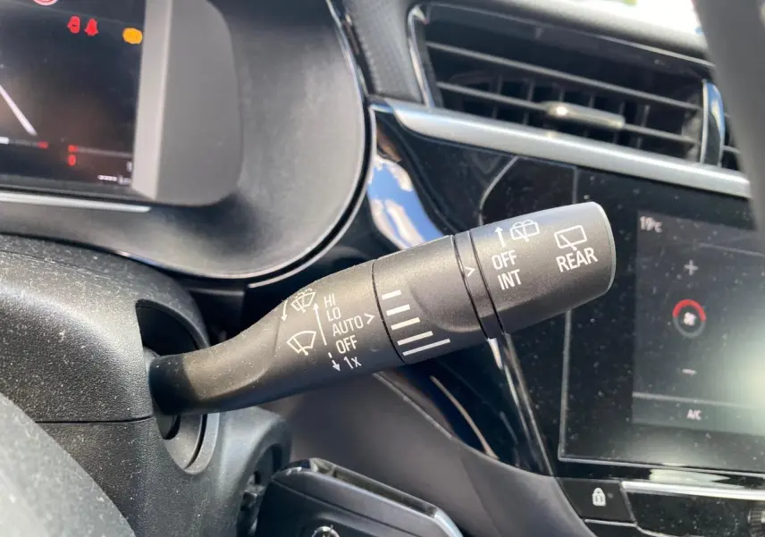 Gros plan sur la commande d’essuie-glace à gauche du volant dans l’habitacle noir brillant de l’Opel Corsa 2021.