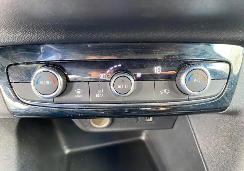Gros plan sur la commande de climatisation automatique de l’Opel Corsa 1.2i Turbo 2021, avec affichage digital et boutons rotatifs.