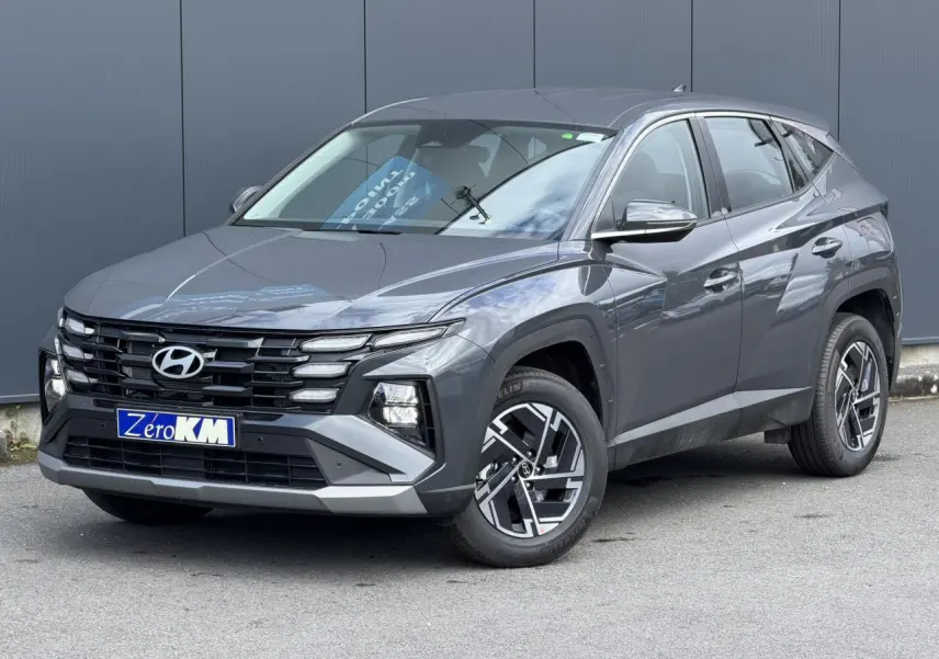 Hyundai Tucson 2026 Ecotronic Gray en 3/4 avant droit, avec jantes alliage et calandre noire distinctive.