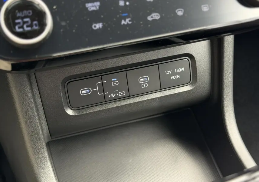 Gros plan sur la console centrale du Hyundai Tucson 2026, montrant les ports USB-C et prise 12V intégrés.