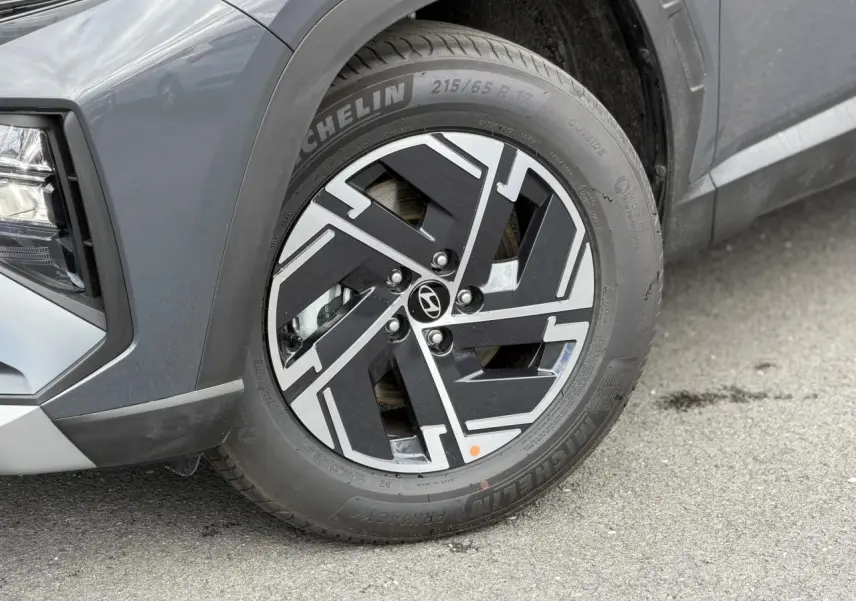 Gros plan sur la roue avant gauche d’un Hyundai Tucson Ecotronic Gray, jante alliage noire et argentée, pneu Michelin.
