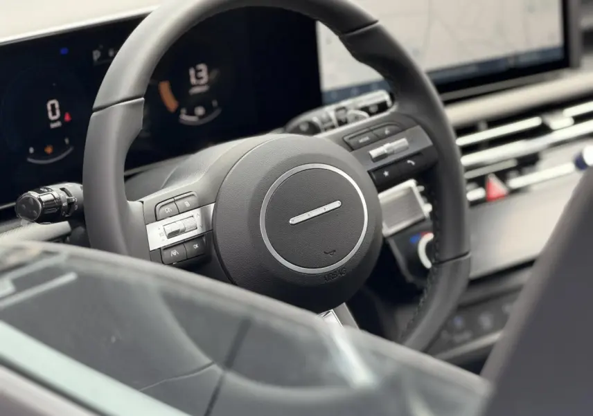Gros plan sur le volant noir et le tableau de bord numérique du Hyundai Tucson 2026, intérieur moderne et épuré.