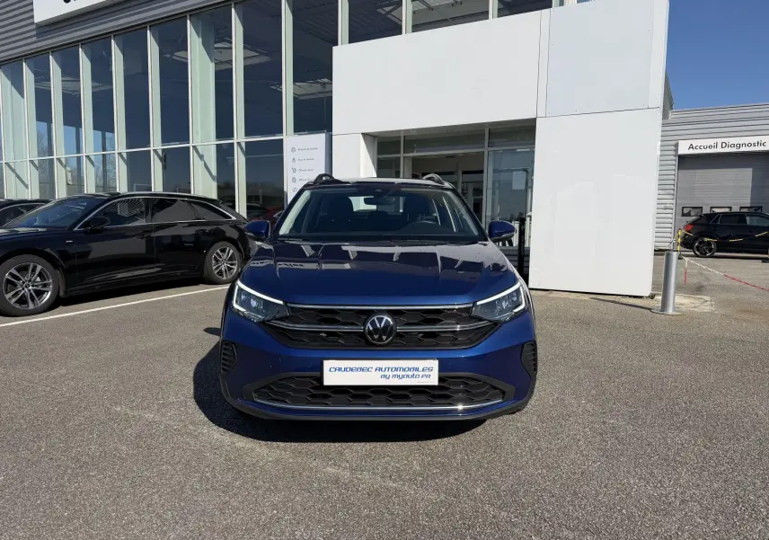 Volkswagen Taigo bleu métallisé vue de face, avec calandre noire et phares LED allumés.
