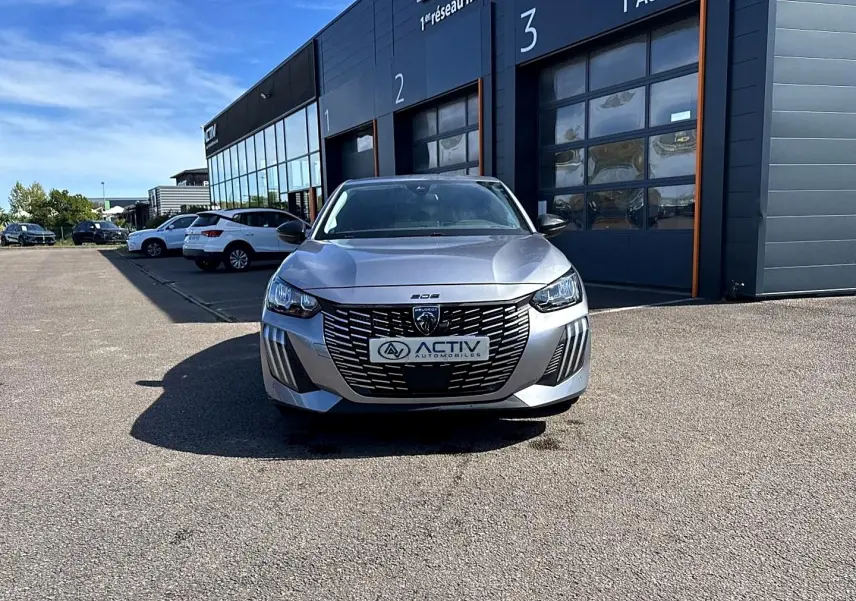 Peugeot 208 1.2 100 Allure gris Artense vue de face, avec calandre noire et phares LED marquants.