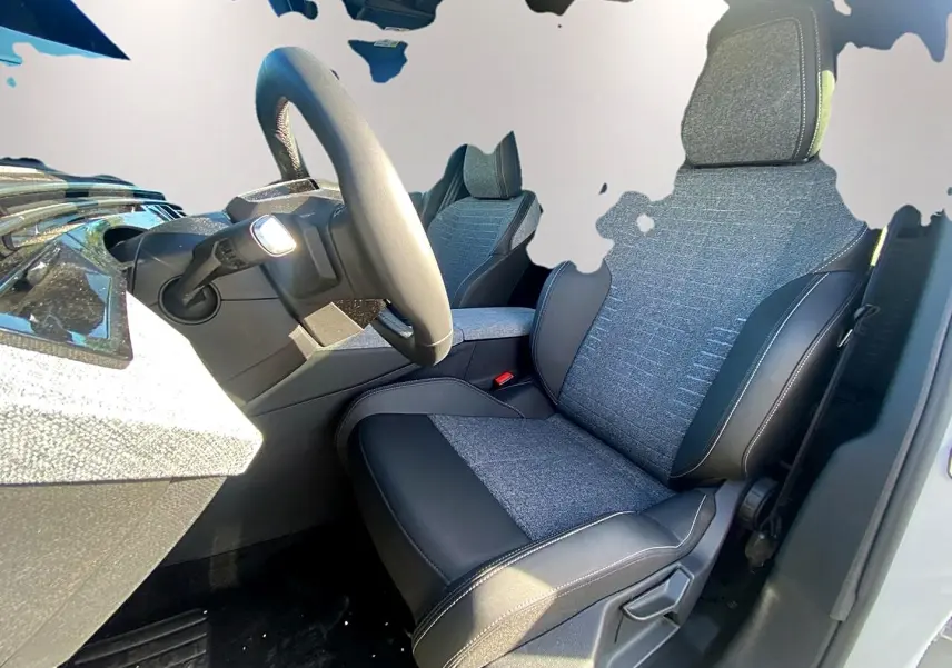 Vue intérieure côté conducteur du Peugeot 5008 Hybrid 145 allure e-dcs6 2025 avec sièges tissu et cuir gris.