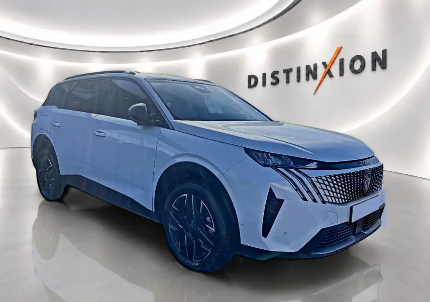 Peugeot 5008 blanc en 3/4 avant droit dans un showroom avec calandre distinctive et jantes noires.