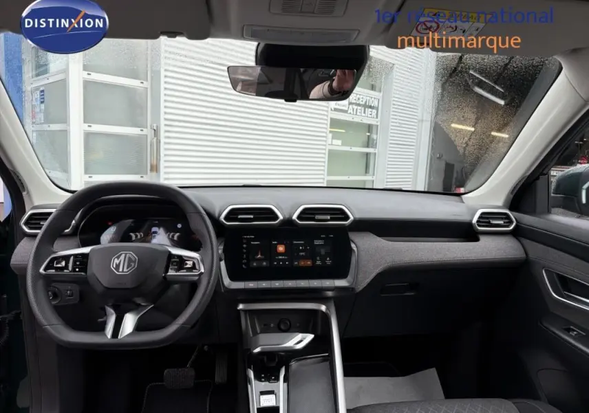 Intérieur du MG MOTOR ZS 2026 vert foncé, vue de face sur le tableau de bord avec écran tactile et volant multifonction.
