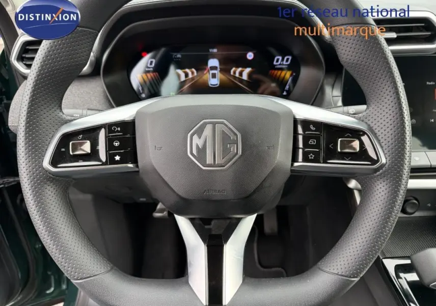 Vue rapprochée du volant perforé noir du MG ZS hybride 2026, avec tableau de bord numérique en arrière-plan.