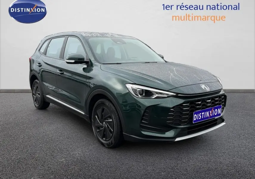 MG ZS hybride vert foncé en 3/4 avant droit, avec calandre noire et jantes foncées, sur fond neutre intérieur.