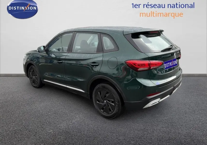 Vue 3/4 arrière droite d’un MG ZS vert foncé hybride avec jantes noires et détails chromés au niveau du pare-chocs.