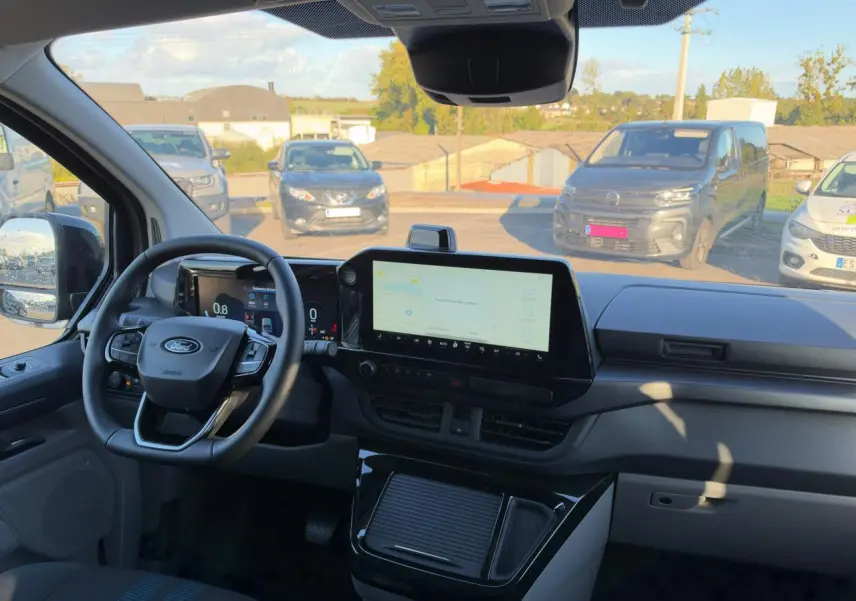 Vue intérieure du tableau de bord du Ford Transit Fourgon noir, avec écran tactile central et volant multifonction.