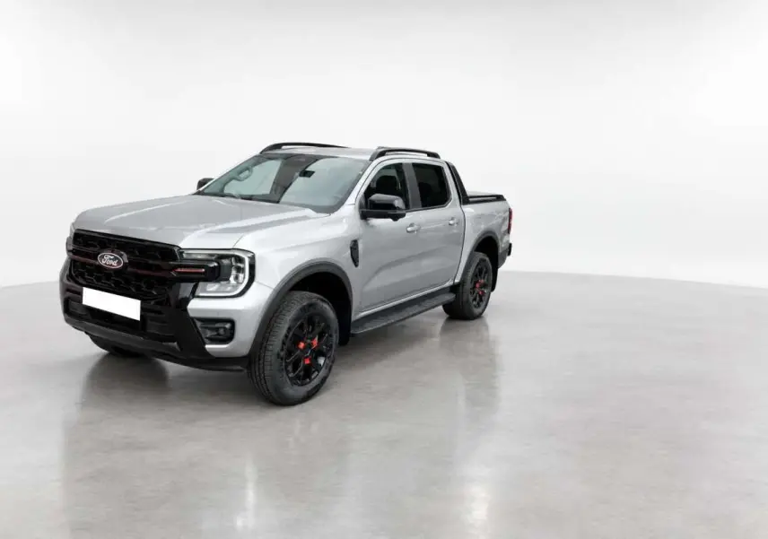 Ford Ranger Wildtrak gris iconic vu en 3/4 avant droit, avec jantes noires et détails rouges sur roues.