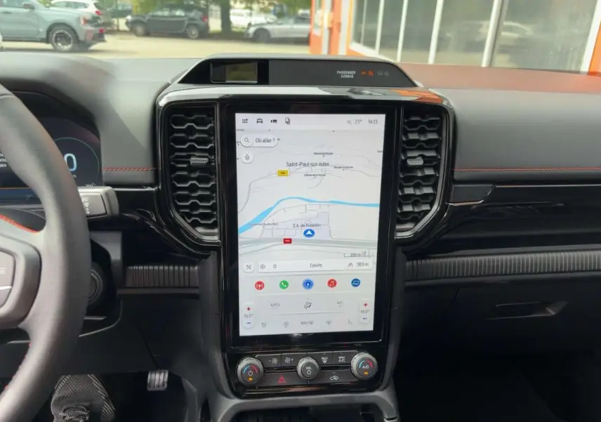 Vue rapprochée du tableau de bord noir du Ford Ranger Wildtrak 2026 avec écran tactile vertical affichant la navigation.