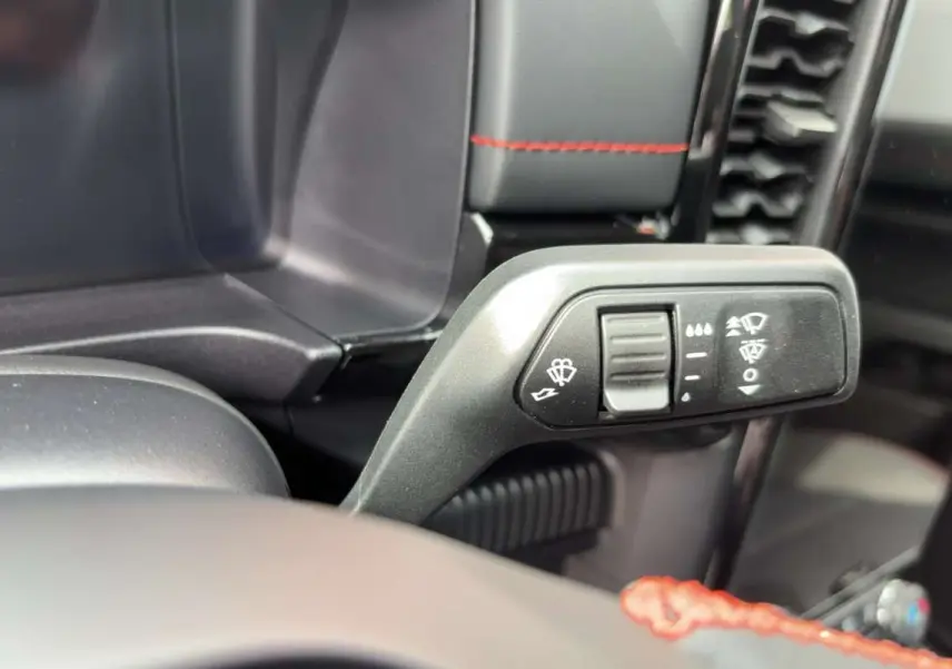 Gros plan sur la commande des essuie-glaces dans l’habitacle du Ford Ranger gris iconic, avec surpiqûres rouges visibles.